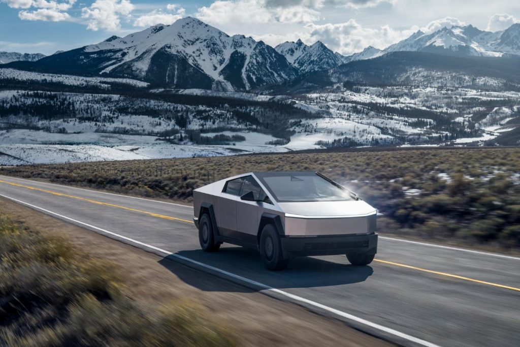 Cybertruck proibida na Europa, confirma exército americano 3 Cybertruck com o seu perfil anguloso viola as normas de segurança da Europa. A imagem mostra uma Cybertruck da Tesla a circular numa estrada com montanhas cobertas de neve ao fundo