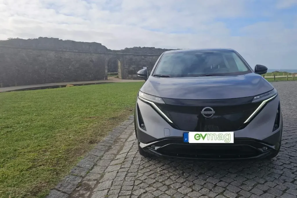 Carregamentos na rede pública cresceram 45% 5 Nissan Ariya visto de frente, estacionado em frente de um pequeno forte costeiro