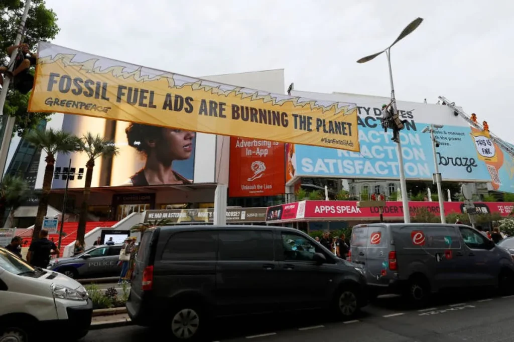 O "novo tabaco": mais de 50 cidades proíbem publicidade a combustíveis fósseis 8 ativistas do Greenpeace com cartaz a pedir o fim da publicidade a combustíveis fósseis