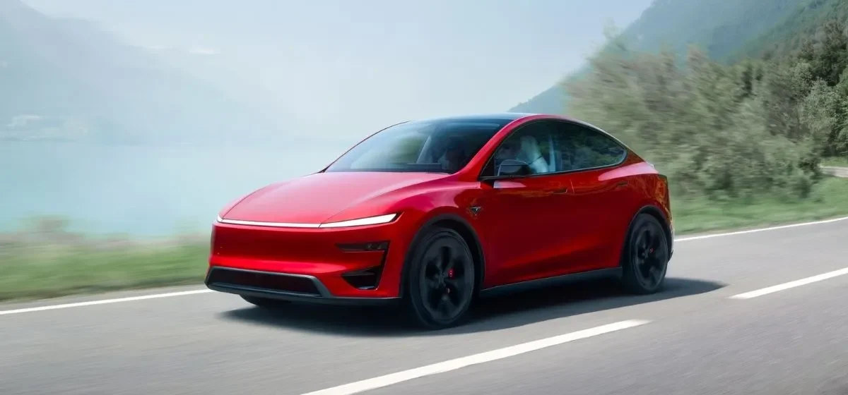 Tesla Model Y vermelho em estrada de montanha julho
