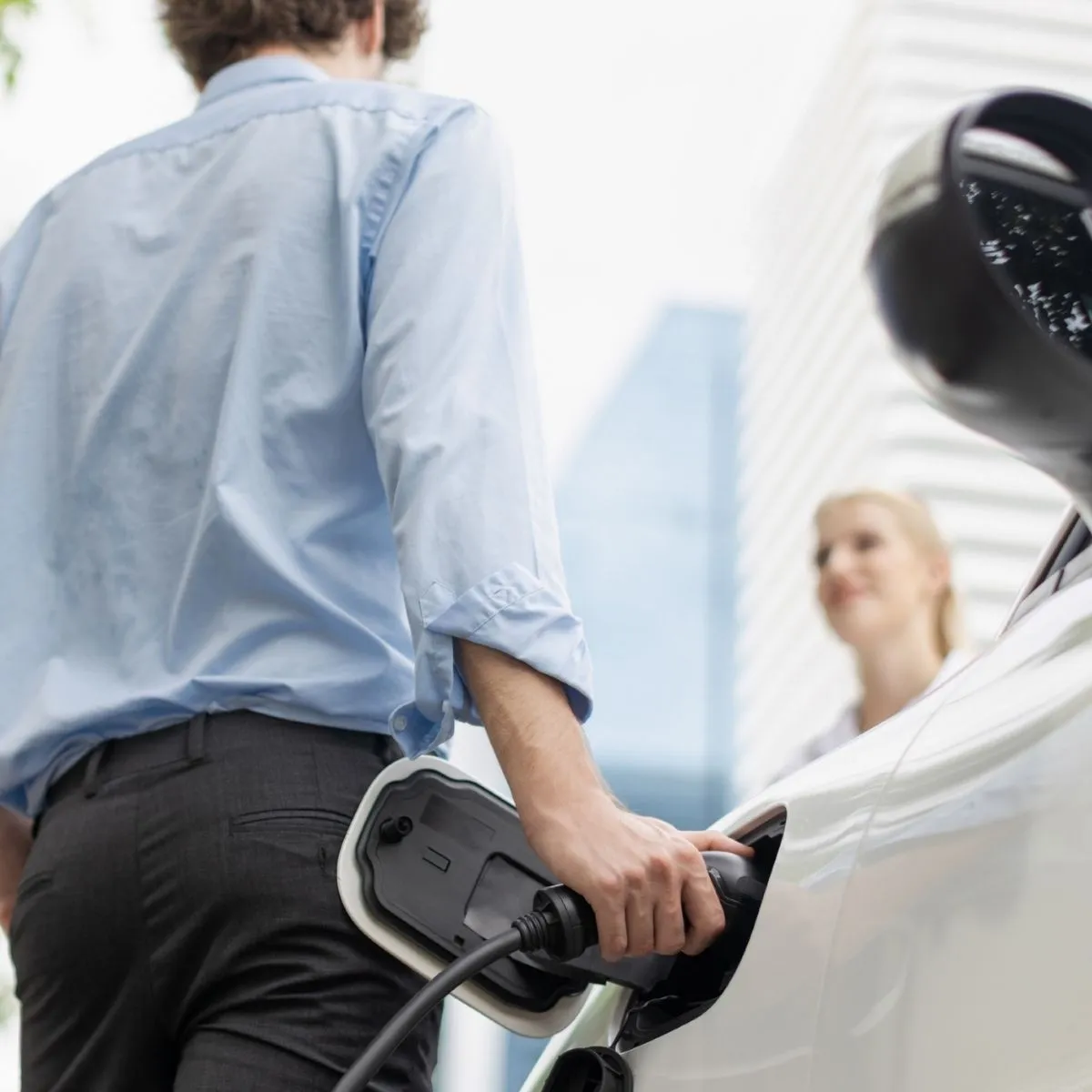 Ministra do Ambiente anuncia incentivo para maio ou junho 2 duas pessoas conversam num stand. o incentivo à compra de carros elétricos regressa em maio ou junho