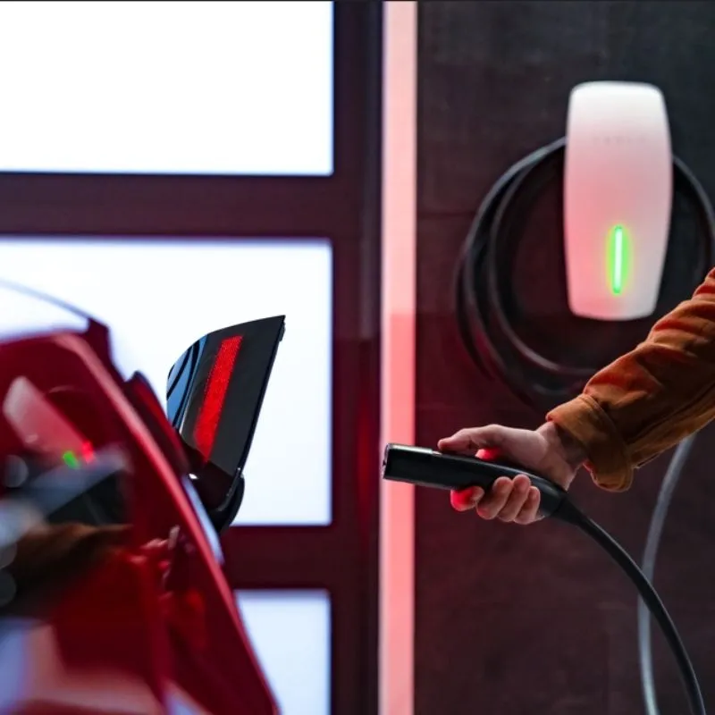 Guia para comprar o primeiro carro elétrico sem traumas 5 Um homem aproxima a ficha de carregamento do automóvel. Saber onde carregar é crucial para a compra do primeiro carro elétrico